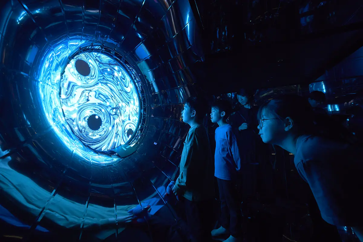 Children looking into a round glowing monitor