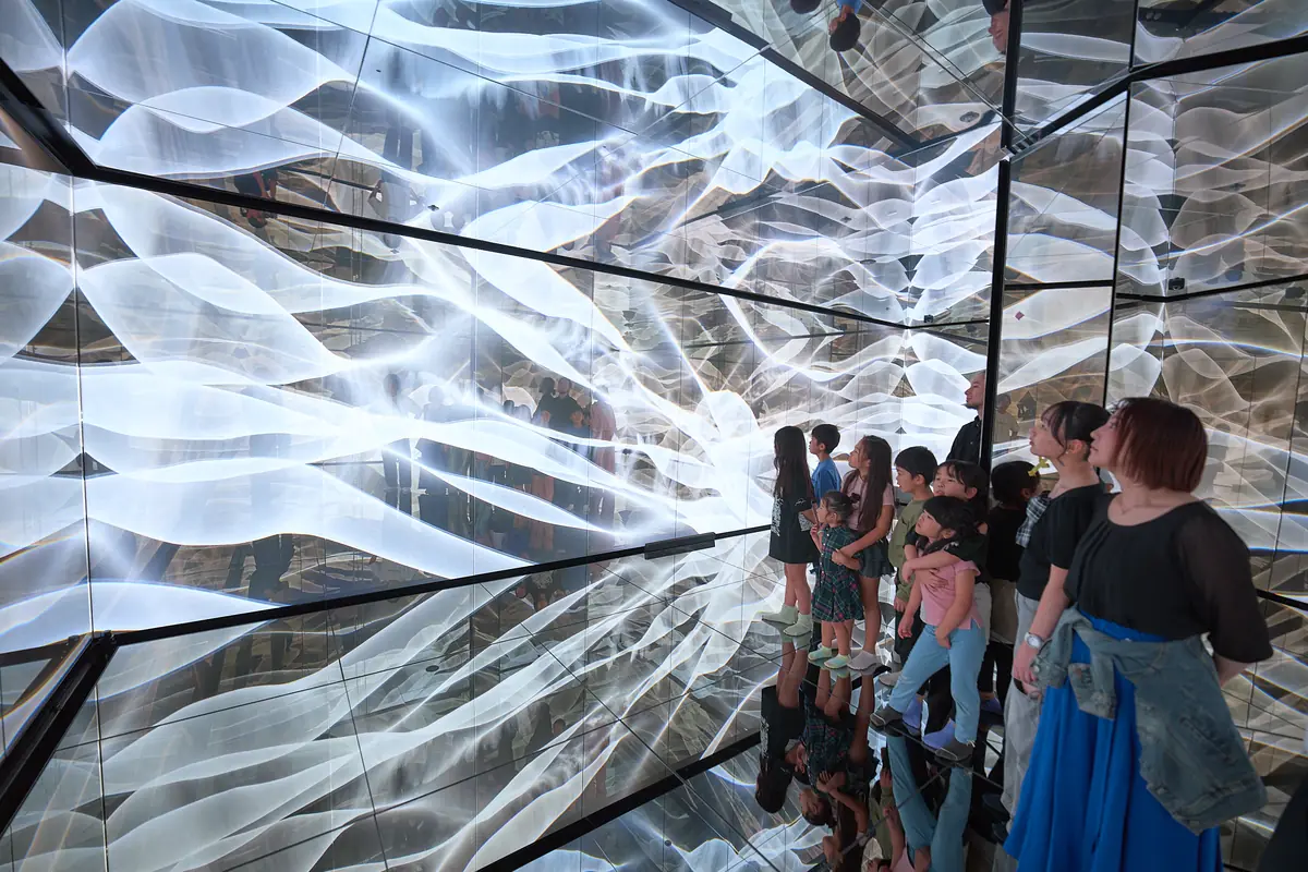 Visitors surrounded by white waves of light
