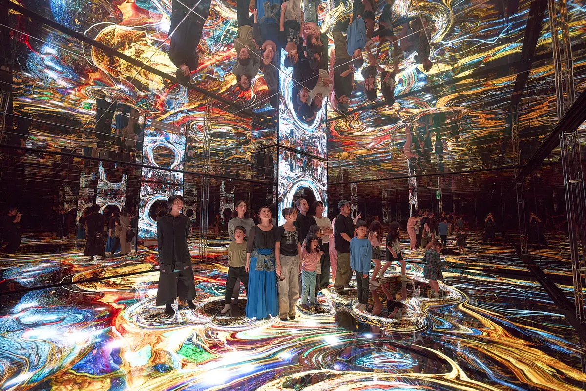 Visitors standing on a floor of flowing liquid light